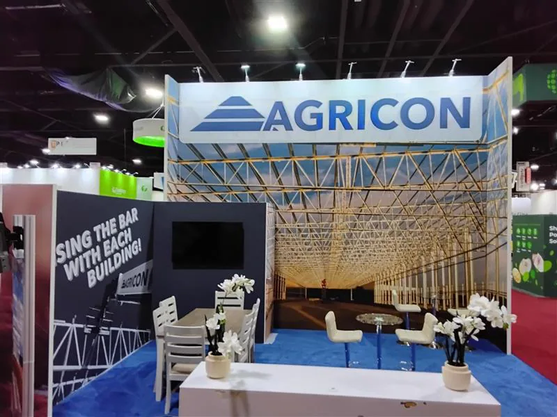 Graphic-led corner exhibit with a blue lounge area and tall framed walls.
